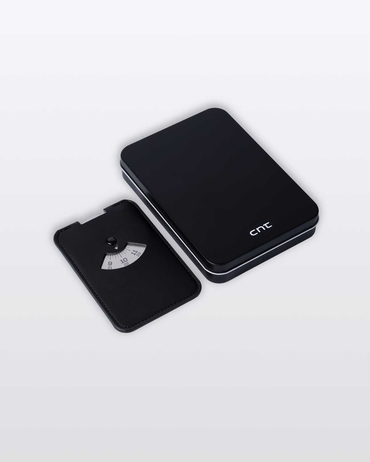 A black PU leather parking disc with silver disc, with its metal box with a white cnt logo beside it on a clean light gray background. 